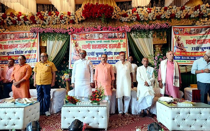Dignitaries standing on stage during the 77th Punya Tithi program